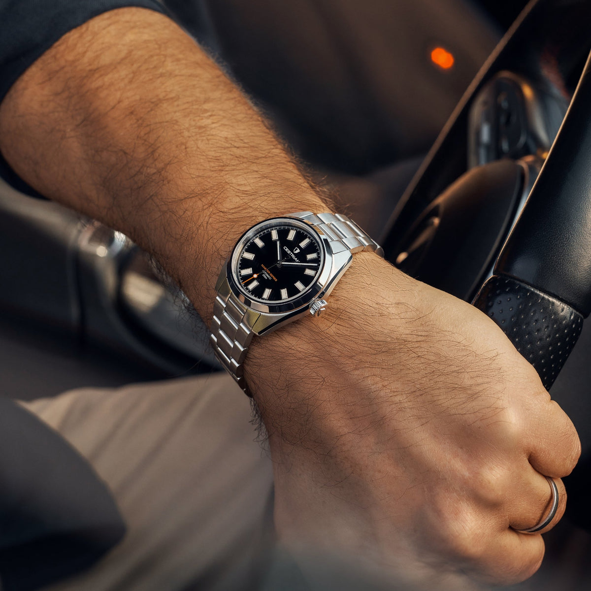 Cestrian Master Series CM-BK001 lifestyle shot of black dial steel watch on wrist at car steering wheel
