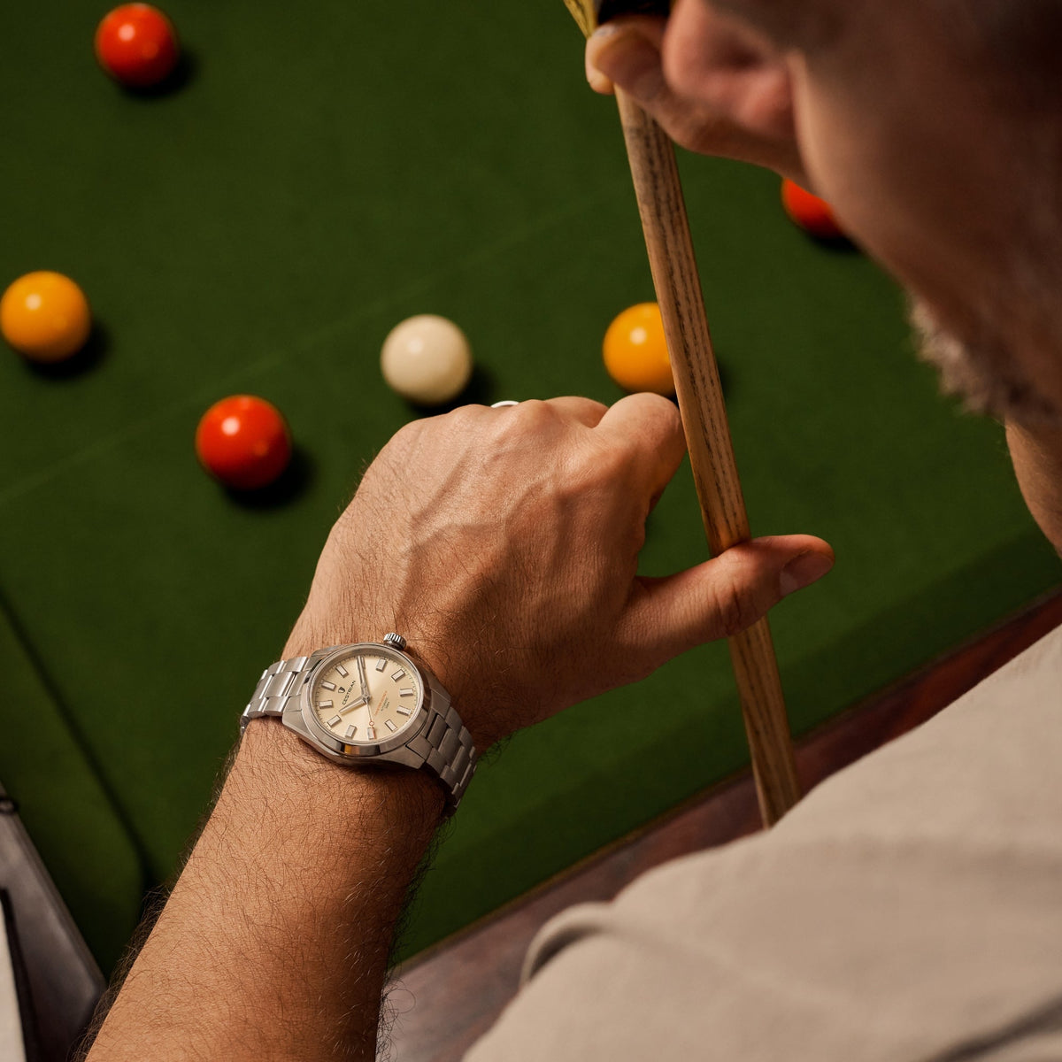 Cestrian Master Series CM-CH001 lifestyle shot of champagne dial steel watch worn on wrist at snooker table