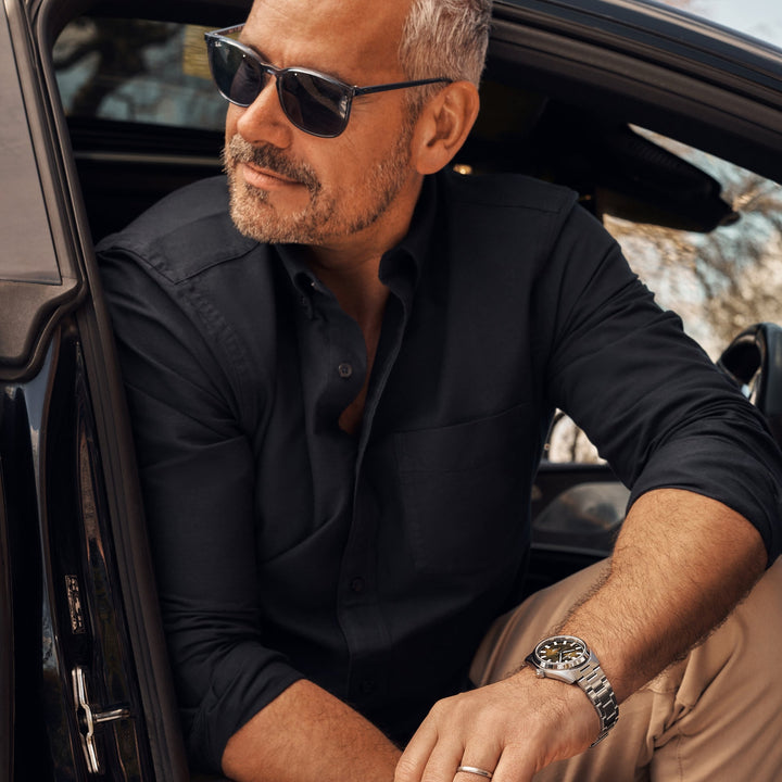 Cestrian Master Series CM-GB001 lifestyle portrait of model wearing steel bracelet watch seated in open car doorway